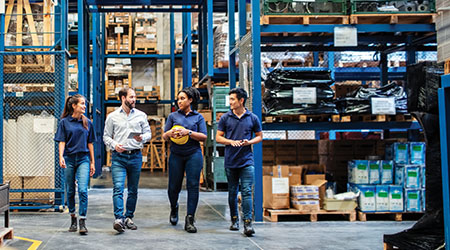 Four workers walking in distribution center